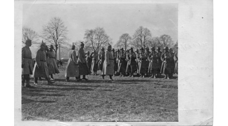 Truppenparade während des Ersten Weltkrieges auf dem Burggelände. Im Vordergrund Offiziere, im Hintergrund das Gewehr präsentierende Soldaten
